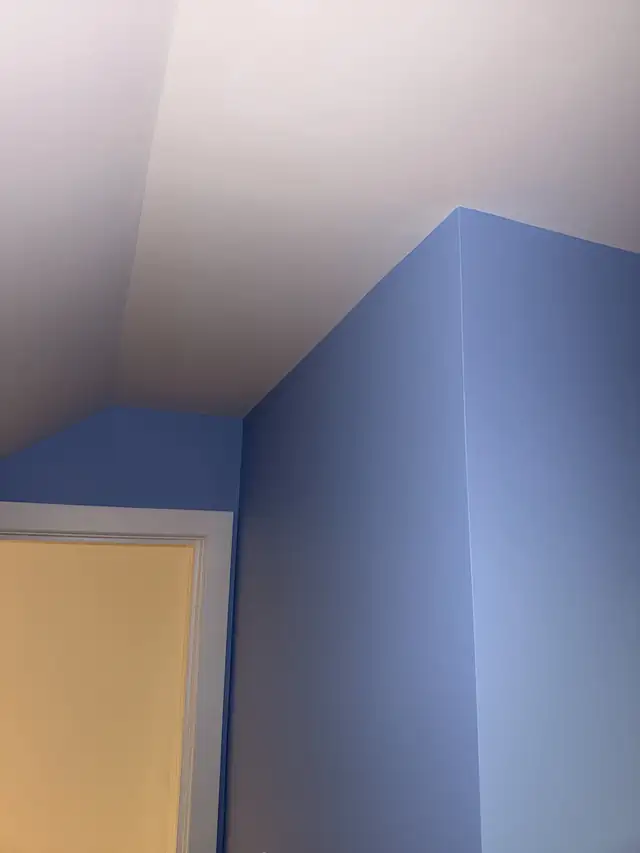Freshly painted lavender blue walls meeting a white ceiling